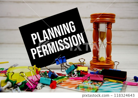 Planning Permission text on paper card with hourglass and stationary on wooden background 118324643