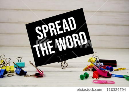 Spread The Word text on paper card with stationary on wooden background 118324794