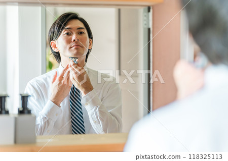 一位身穿西裝的年輕亞洲商人早上上班前在浴室刮鬍子 118325113