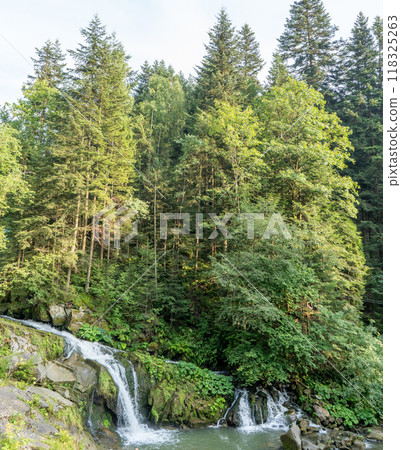 Mountain waterfall in the forest. Green nature. Mountain waterfall in the forest. Green nature. 118325263