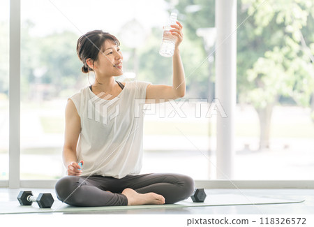 穿著運動服的女性訓練後補水 穿著運動服的女性訓練後補水 118326572