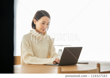 A woman who operates a personal computer in the living room 118327163