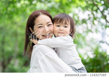 媽媽抱著她的女兒，新鮮的綠色 118327385