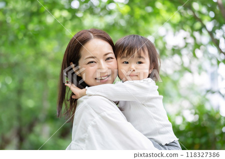 Mother holding her daughter, fresh greenery 118327386