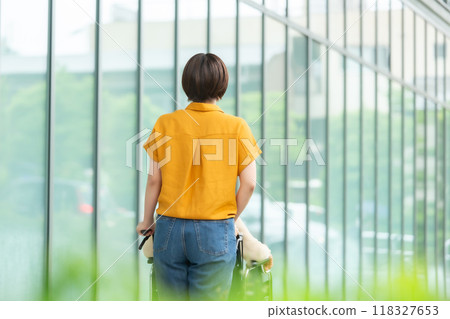 一位坐在輪椅上的老年婦女和一位照顧她的年輕婦女，後視圖 118327653