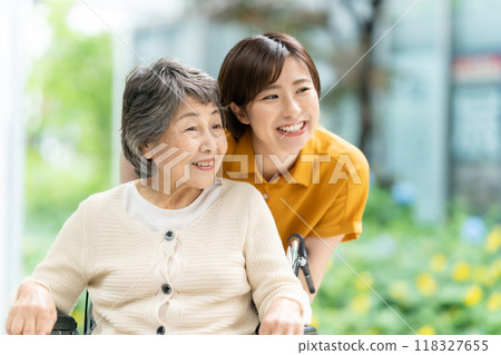 一名坐在輪椅上的老年婦女和一名照顧她的年輕婦女 118327655