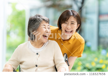 一名坐在輪椅上的老年婦女和一名照顧她的年輕婦女 118327656