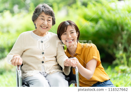 Senior woman in a wheelchair and young woman caring for her Senior woman in a wheelchair and young woman caring for her 118327662