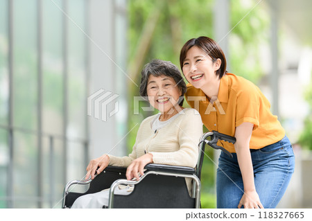 Senior woman in a wheelchair and young woman caring for her Senior woman in a wheelchair and young woman caring for her 118327665