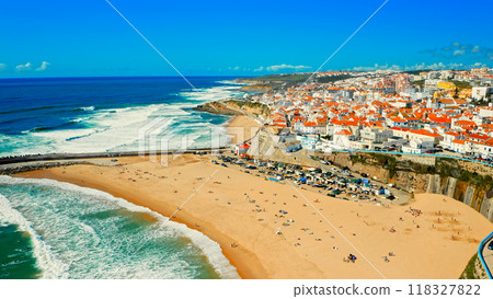 Drone view to Beautiful resort touristic town on ocean background. Aerial view - Beautiful travel destination with sandy beach. Tourist beach for surfing while vacation at Ericeira, in Summer. Drone view to Beautiful resort touristic town on ocean background. Aerial view - Beautiful travel destination with sandy beach. Tourist beach for surfing while vacation at Ericeira, in Summer. 118327822