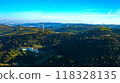 Wind farm generating green energy. Wind turbines with blades in field aerial view. Alternative energy. Scenic Aerial view of wind turbines farm over green beautiful landscape. 118328135