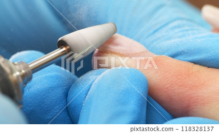 Manicurist in process of removing gel polish or acrylic from nails using  manicure machine. Process of hardware manicure in the salon.  Nail manicure process in a beauty salon. Nail beauty salon. 118328137