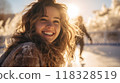 Beautiful girl ice skating on a nice winter day. Closeup portrait of a happy young girl ice skating. An attractive young lady smiling on an ice skating ring. 118328519