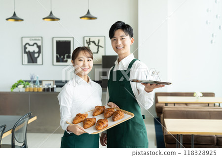 Young men and women working in a cafe 118328925