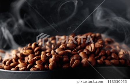 Steaming coffee beans on a black background. Steaming coffee beans on a black background. 118330933