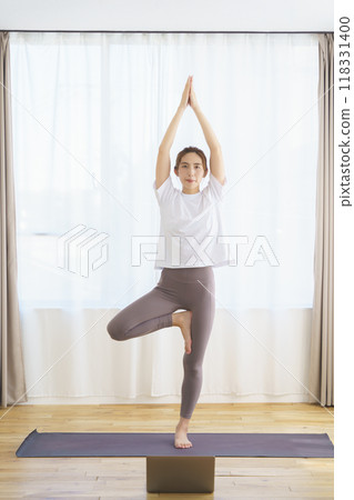 A young woman delivering an online yoga salon A young woman delivering an online yoga salon 118331400