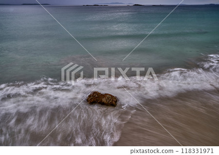 long exposure beach waves around rock cloudy day long exposure beach waves around rock cloudy day 118331971