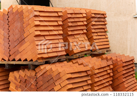 Stacks of new, red ceramic brick stacked on wooden pallets. Stacks of new, red ceramic brick stacked on wooden pallets. 118332115