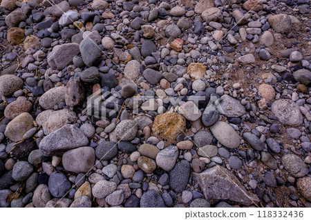 Round stone on the riverbed 118332436
