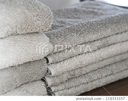 Clean grey towels folded and stacked on a shelf Clean grey towels folded and stacked on a shelf 118333357
