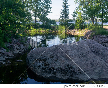 shady decorative pond with stone banks in the park 118333442