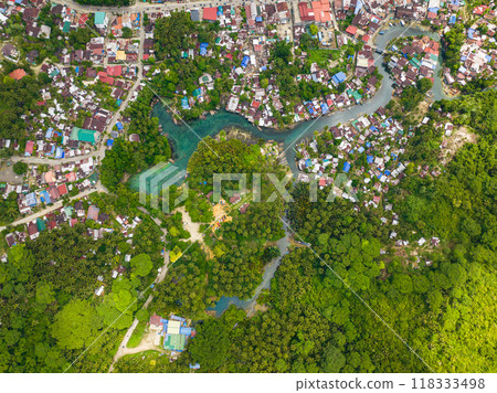Top view of clear water and traditional boats surrounded by tropical forest. Bogac Cold Spring in Surigao del Sur. Philippines. Top view of clear water and traditional boats surrounded by tropical forest. Bogac Cold Spring in Surigao del Sur. Philippines. 118333498