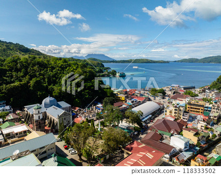 Aerial view of commercial buildings and streets in Romblon Island. Ferry over the blue sea. . Romblon, Philippines. 118333502