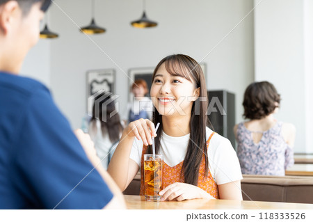 Young men and women relaxing in a cafe Young men and women relaxing in a cafe 118333526