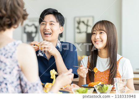 Young men and women having lunch at a cafe Young men and women having lunch at a cafe 118333948