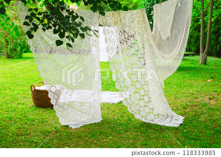 White laundry on clothesline in garden. White curtains drying in the sun. 118333985