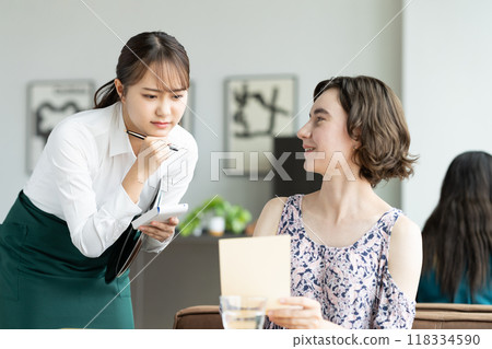 A young female store clerk is worried about serving foreign tourists 118334590