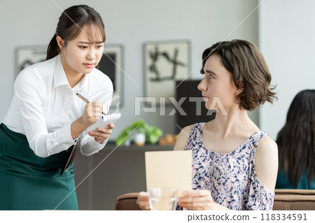 A young female store clerk is worried about serving foreign tourists 118334591