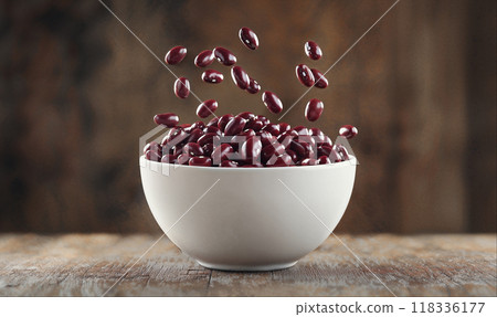 Red beans falling into white bowl on rustic wooden background with copy space, hight detailed upscaled image 118336177