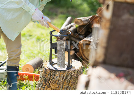 The hands of a woman chopping firewood 118338174