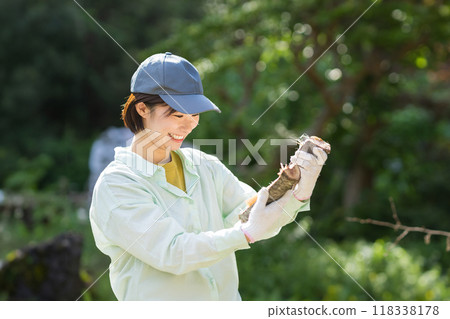 Woman looking at cut firewood, farm work 118338178