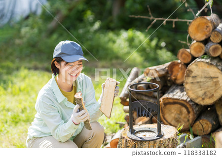 Woman looking at cut firewood, farm work 118338182