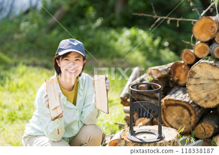 A woman chopping firewood 118338187