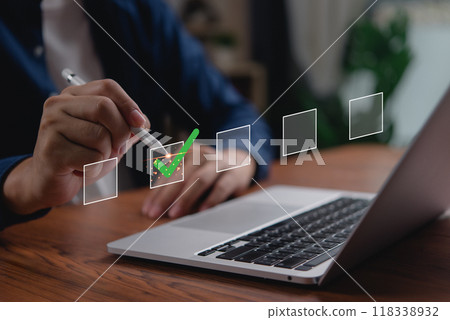 Businessperson completing digital checklist on laptop. Concept of productivity and task management. Useful for project planning, organizational strategy, and corporate efficiency visuals. Businessperson completing digital checklist on laptop. Concept of productivity and task management. Useful for project planning, organizational strategy, and corporate efficiency visuals. 118338932