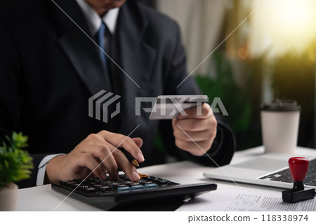 Businessman using calculator and holding credit card. Concept of finance, accounting, payment calculation. Suitable for financial services, business management. 118338974