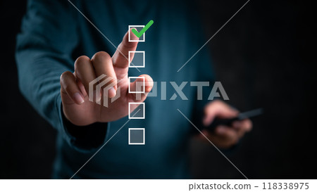 Hand touching checklist, green check mark highlighted. Concept of task completion, decision making, digital interface. Useful for business processes, project management. Hand touching checklist, green check mark highlighted. Concept of task completion, decision making, digital interface. Useful for business processes, project management. 118338975