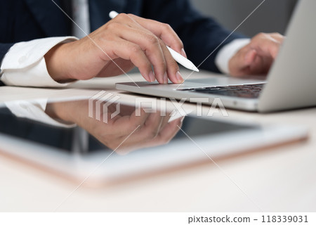Businessman typing on a laptop with a stylus pen, representing professional office work. modern workspace and digital business activities. office productivity guides, and corporate presentations. 118339031