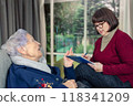 Elderly care in action: Social worker listens intently, taking notes as senior resident speaks passionately about her experiences. 118341209