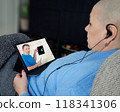 Post-chemo patient consults remotely with surgeon, who uses X-rays to explain upcoming procedure, demonstrating accessible care. 118341306