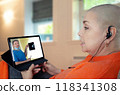 Cancer survivor participates in virtual medical discussion, attentively listening to doctor's explanation of X-ray findings on tablet. 118341308