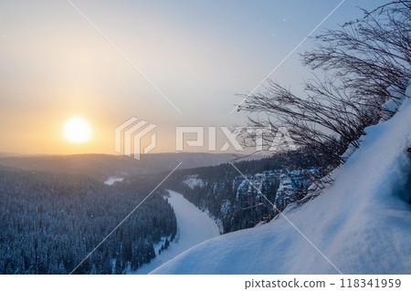 Beautiful sunrise on a frosty morning, a snowy cliff, trees on the edge. Beautiful sunrise on a frosty morning, a snowy cliff, trees on the edge. 118341959