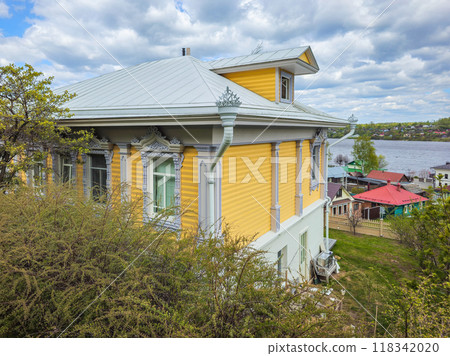 Traditional Russian log house, a yellow house in the village. 118342020