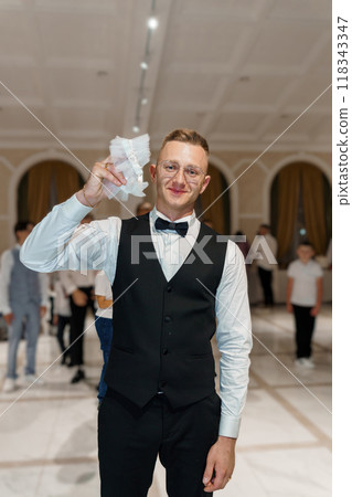 Elegant Gentleman Holding Garter in a Grand Wedding Reception Hall Elegant Gentleman Holding Garter in a Grand Wedding Reception Hall 118343347