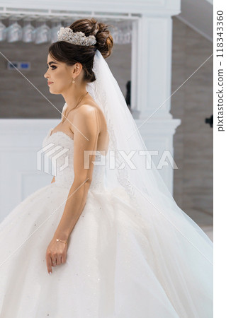 Elegant Bride in Exquisite White Gown and Sparkling Tiara, Captured in Graceful Wedding Ambiance 118343360