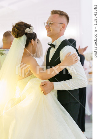 Enchanting First Dance of a Newlywed Couple Amidst Joyful Celebration 118343363