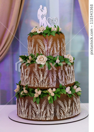 Elegant Three-Tier Chocolate Wedding Cake with Floral Decorations and Rustic Patterns Elegant Three-Tier Chocolate Wedding Cake with Floral Decorations and Rustic Patterns 118343368
